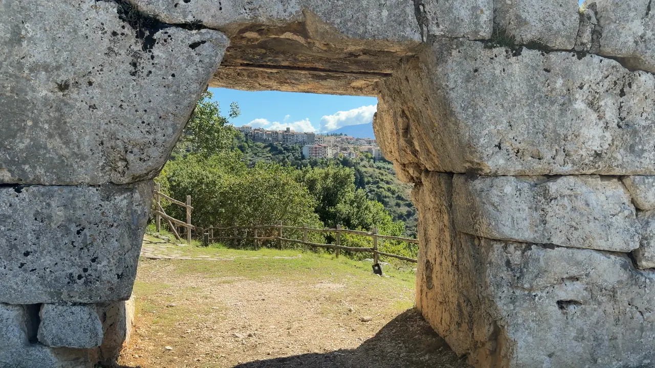 Segni incorniciata dall’arco della postierla, il paese arroccato sulla collina di fronte